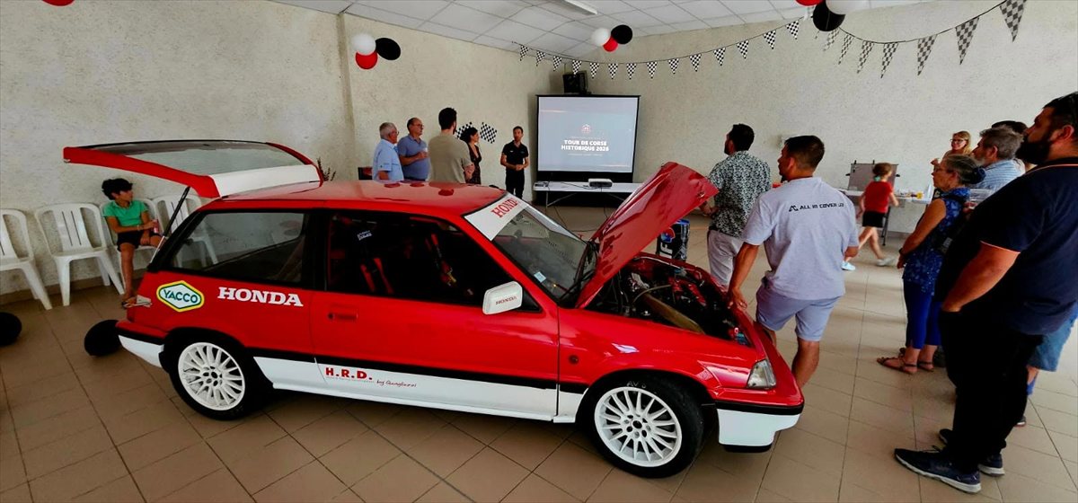Les invités autour de la Honda Civic, capot ouvert, pendant la présentation de l'équipage à la salle des fêtes de Peyrouzet