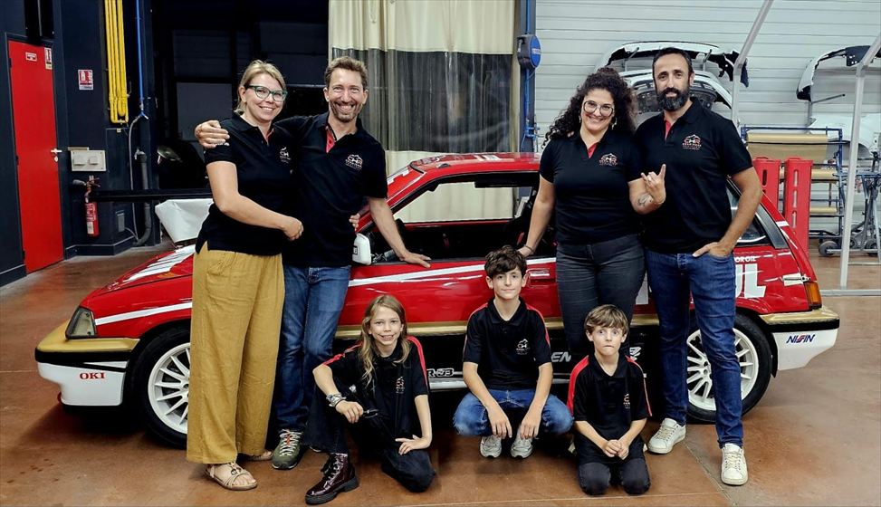 L'équipe en polos Comminges Heritage Racing avec les enfants devant la voiture